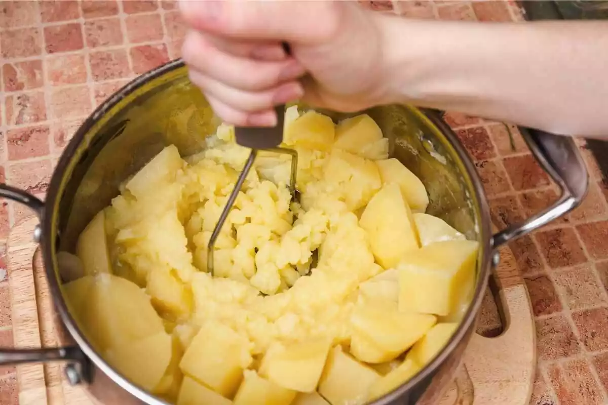 patata asada con una persona aplastándolas