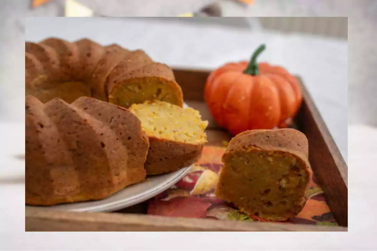 Foto de un bizcocho de calabaza con un trozo cortado y de fondo una calabaza. Detrás, una foto desenfocada Foto de un bizcocho de calabaza con un trozo cortado y de fondo una calabaza. Detrás, una foto desenfocada